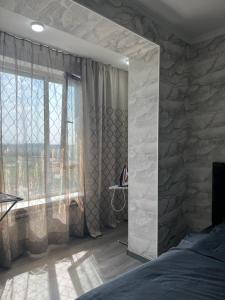 a bedroom with a stone wall and a large window at Аэропорт apartments in Pokrovka +9 photos