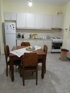 a kitchen with a table and chairs and a refrigerator at Ελένης apartment in Gythio