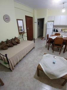 a bedroom with a bed and a kitchen with a table at Ελένης apartment in Gythio