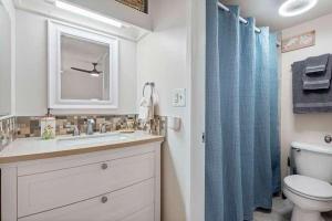 a bathroom with a sink and a toilet and a window at Kona Alii 407 in Kailua-Kona +23 photos