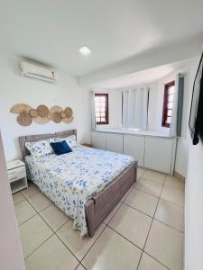 a bedroom with a bed in a white room at Chalé Gravatá - Privê Jardim de Marie in Gravatá