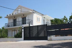 a white house with a black gate in front of it at Villa Green Escape in Dugobabe