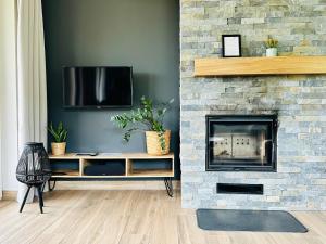 a living room with a stone fireplace with a tv at Bukowe Tarasy in Wetlina