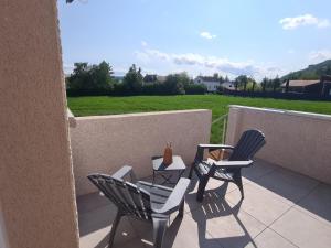 a patio with two chairs and a table on a balcony at Le Nid du Bosquet in Issoire