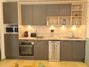 a kitchen with gray cabinets and a sink at Le Nid du Bosquet in Issoire