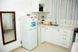 a kitchen with a white refrigerator and a sink at Departamento en Chimbote con cochera in Chimbote