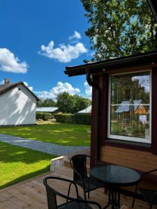 a patio with a table and chairs on a porch at Vilties vila in Anykščiai +11 photos