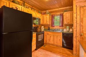セバービルにあるHidden Romance #1404のキッチン(黒い冷蔵庫、木製キャビネット付)