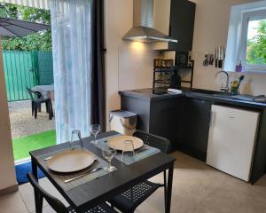 a kitchen with a table with wine glasses on it at Stop Chez M Daisy # Qualité # Confort # Simplicité in Irigny