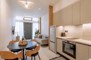 a kitchen and living room with a table and chairs at LINERIA luxury living in Ágios Rókkos