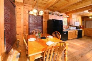 a kitchen with a wooden table with chairs and a black refrigerator at A Bit of Heaven #252 in Sevierville