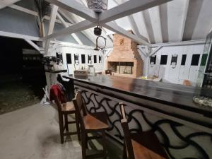 a kitchen with a bar with two chairs and a fireplace at La Andrei in Taşca