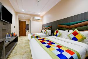 a hotel room with two beds and a flat screen tv at The Pearl Plaza Hotel - Walking Distance From New Delhi Railway Station and Connaught Place in New Delhi