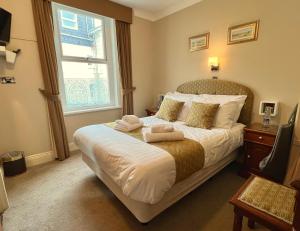 a bedroom with a bed with towels on it at Riviera Lodge Hotel in Torquay