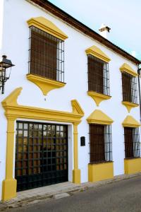 a white building with yellow trim and windows at Casa Rural MIRASIERRA in Hornachuelos