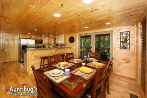 a kitchen and dining room with a wooden table and chairs at A Secluded Retreat #216 in Pigeon Forge