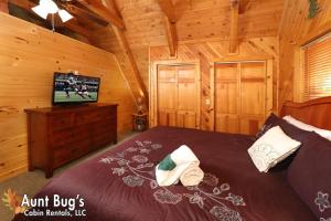 a bedroom with a bed and a tv in a cabin at A Secluded Retreat #216 in Pigeon Forge