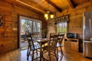 a dining room with a table and chairs in a cabin at Almost Heaven #205 in Sevierville