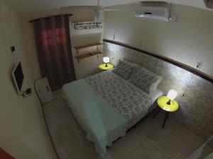 a small bedroom with a bed and two lamps at Suítes da Villa - Hospedaria in Lençóis