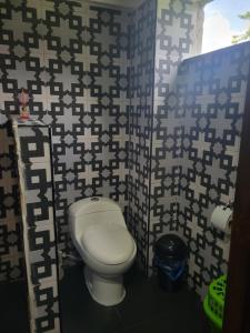 a bathroom with a toilet in a room with a wall at Mi Casa Es Su Casa! El Eden, La Tebaida, Colombia in La Tebaida +12 photos