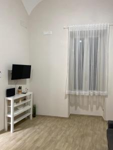 a living room with a tv and a window at La Petite Maison in Naples