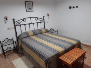 a bedroom with a bed and a wooden table at Casas rurales Casa Noguera in Riópar