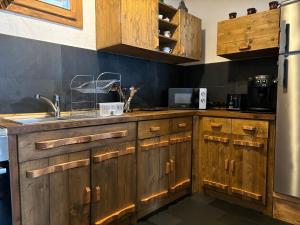 a kitchen with wooden cabinets and a sink at Chalet Ro in Peştera