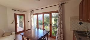 a kitchen with a dining room table and a window at Casa vacanza 70 mq in Valledoria