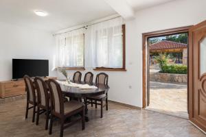LukarにあるVilla PerVaのテーブルと椅子とテレビのあるダイニングルーム