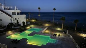 a swimming pool next to the ocean at night at SEAVIEW Luxury PENTHOUSE in Casares