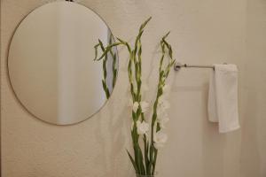 a bathroom with a mirror and a vase of flowers at Casa Mosaicos - Adults only in Puerto Escondido +91 photos