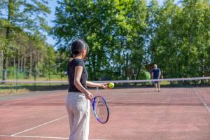 two women playing tennis on a tennis court at Grankullavik Fritidsby in Byxelkrok