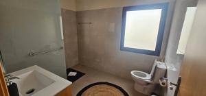 Un baño con inodoro, lavabo y ventana. en Peaceful Valley house, en Câmara de Lobos 39 fotos más
