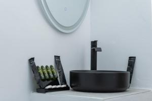 a bathroom with a black sink and a mirror at Allegro seasight appartment in Livadi Astypalaias +6 photos