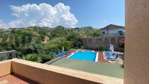 a view of a swimming pool with chairs and a building at Villa Mugs in Tirana