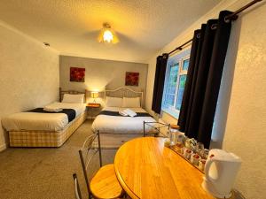 a hotel room with two beds and a table at All Seasons Gatwick Guest House & Parking in Horley +188 photos