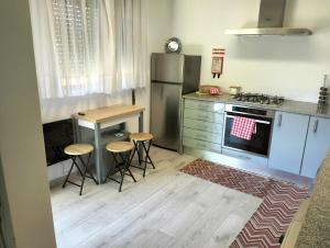 cocina con nevera, mesa y taburetes en CASA NOVA MONTALEGRE, en Montalegre
