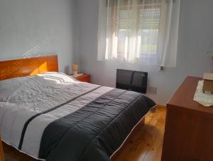 Un dormitorio con una cama, un escritorio y un televisor. en CASA NOVA MONTALEGRE, en Montalegre