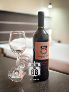 a bottle of wine sitting next to a wine glass at MOTEL MK 66 in Mairinque