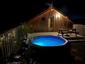 a hot tub on the deck of a cabin at night at Rooftop in Jaure