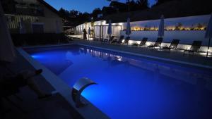 a swimming pool at night with chairs and lights at Vila K2 in Vrdnik