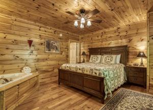 a log cabin bedroom with a bed and a bathtub at Camelot #266 in Pigeon Forge +28 photos