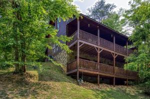 a house with a large deck on a hill at Camelot #266 in Pigeon Forge