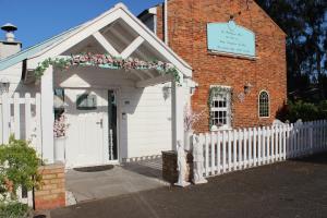 a white church with a white fence and a gate at The Willowford in Milton Keynes