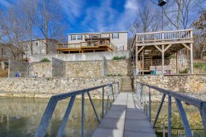 une maison au sommet d'un mur de pierre au bord de l'eau dans l'établissement Gravois Mills Home Boating Vacation!, à Gravois Mills