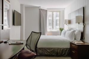 旧金山Club Quarters Hotel Embarcadero, San Francisco的配有一张大床和一张书桌的酒店房间