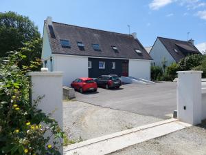 una casa con dos coches aparcados en un estacionamiento en Le 105 - appart-sympa - T2 vue jardin et cave - Larmor-Plage, en Larmor-Plage