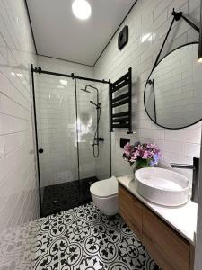 a bathroom with a shower and a toilet and a sink at Home Side Apartment in Batumi