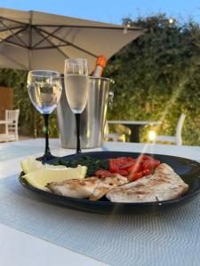 a plate of food on a table with wine glasses at Agriturismo Domus Tuscia in Viterbo