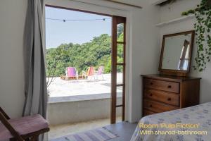 a bedroom with a door open to a patio with chairs at La Bohème Casa Cultural - Santa Teresa in Rio de Janeiro